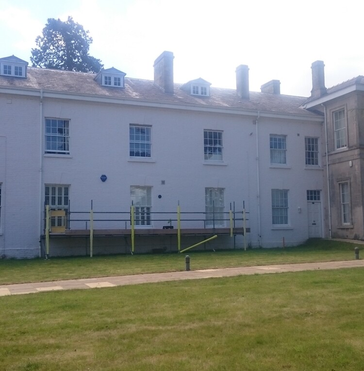 The outside of a freshly-painted, three-storey terraced building.